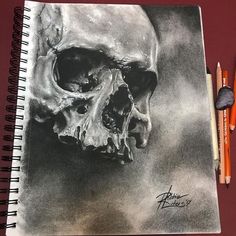 a pencil drawing of a skull on top of a notebook