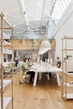 people are sitting at tables in an office