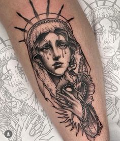 a woman's arm with tattoos on it and an image of the virgin mary