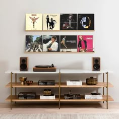 an entertainment center with books, speakers and pictures on the wall