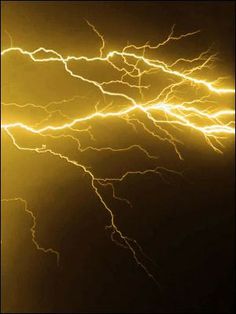 lightning strikes in the night sky with bright yellow and white lights shining on it's side