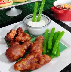 some food is on a white plate with green onions and celery next to it