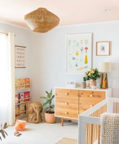 a baby's room with a crib, dresser and pictures on the wall