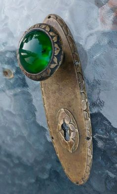 a green ring sitting on top of an old piece of metal in the ocean water