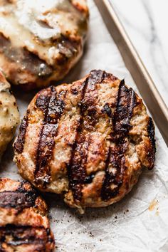 three hamburger patties sitting on top of a piece of paper next to a knife