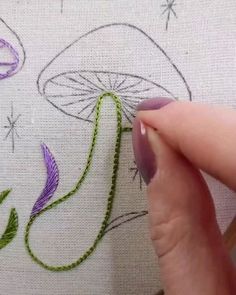 someone is stitching flowers on a piece of fabric