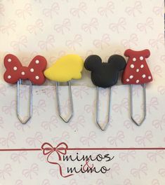 three mickey mouse and minnie mouse hair clips on a white background with red, yellow, and blue polka dots