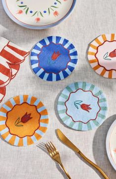 colorful plates and forks are arranged on a table