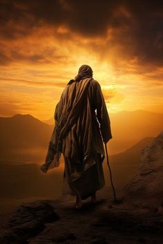 a man with a walking stick is looking out at the sunset on top of a mountain