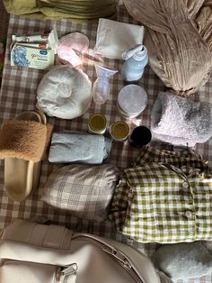 the contents of a diaper bag laid out on a table with cloths and other items