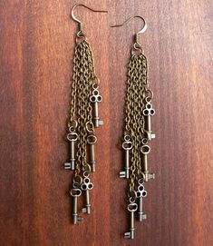 "Surround yourself with the sound of dangling keys, knocking together gently, with our falling keys earrings. These steampunk earrings feature small antique brass keys, suspended from delicate chain and earwires. Measuring about four (4) inches long, these long dangling earrings are sure to add class to any ensemble. \"There is no key to happiness. The door is always open.\" -Mother Teresa **Please note: the earrings you will receive have not been previously worn by a model. Colors in keys may v Steampunk Key, Key Earrings, Steampunk Earrings, Steam Punk Jewelry, Steampunk Wedding, Hammered Hoop Earrings, Key Jewelry, Punk Jewelry, Steampunk Jewelry