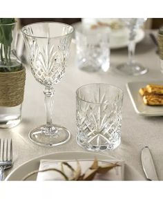 a table set with glasses, plates and silverware