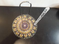 a glass plate with a metal handle sitting on top of a black table next to a straw