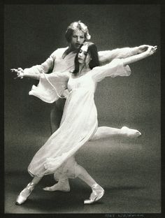 a man and woman dance together in the middle of an artistic pose, with their arms stretched out