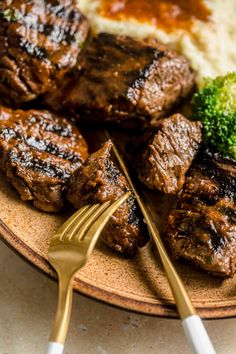 steak, broccoli and mashed potatoes are served on a plate with a fork