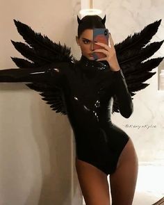 a woman in a bodysuit taking a selfie with an angel wings on her head