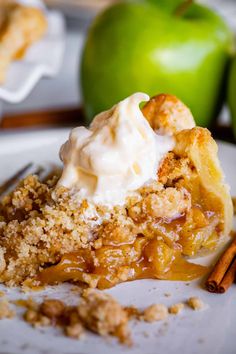 a slice of apple pie on a white plate with cinnamon and apples in the background