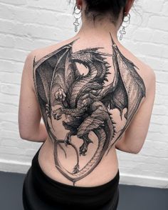 a woman with a dragon tattoo on her back