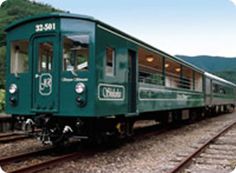 a green train car sitting on the tracks