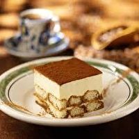 a piece of cake sitting on top of a white plate next to a cup and saucer