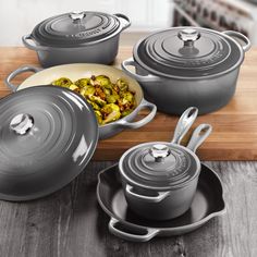 an assortment of pots and pans on a wooden table