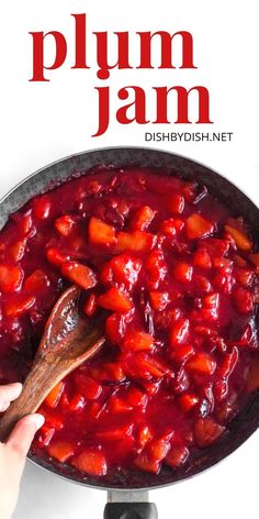 plum jam in a skillet with a wooden spoon and text overlay that reads plum jam