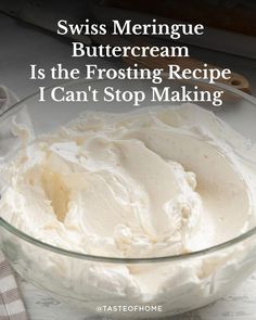 a glass bowl filled with white frosting on top of a table