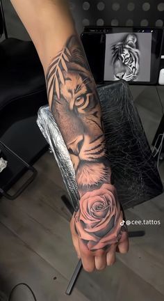 a person with a tiger and rose tattoo on their arm is holding a knife in the other hand