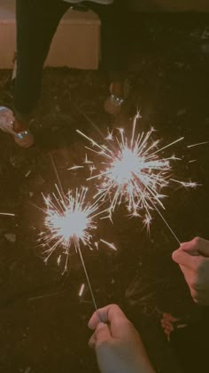 two people are holding sparklers in their hands