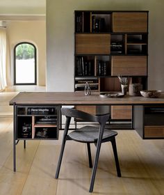 a table with two chairs in front of it and bookshelves on the wall