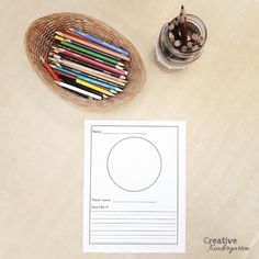 a basket with colored pencils next to a paper on a table