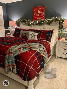 a bedroom decorated for christmas with red and green plaid comforter, white bedding, and lights