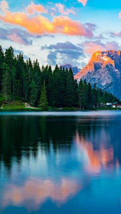 the mountains are reflected in the still water of this mountain lake at sunset or sunrise