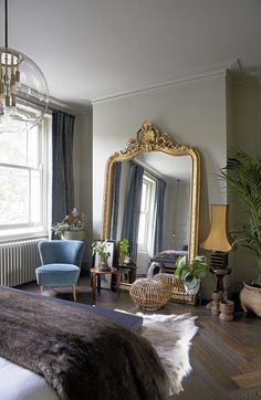 a bedroom with a bed, chair and mirror in it's centerpieces