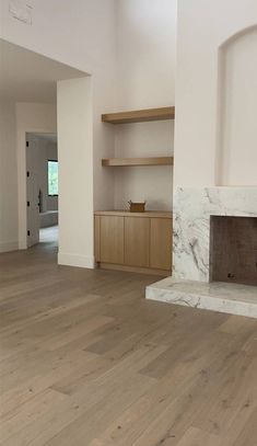 an empty living room with white walls and wood flooring is pictured in this image