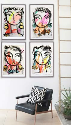 three paintings hanging on the wall next to a chair and ladder in a living room