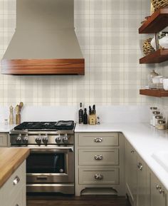 a stove top oven sitting inside of a kitchen next to a counter and shelves filled with bottles