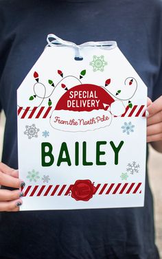 a person holding up a sign that says special delivery from the north pole bailey on it