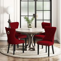 a round dining table with red chairs around it and a white rug on the floor