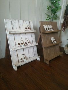 two white wooden shelves sitting on top of a hard wood floor next to a potted plant