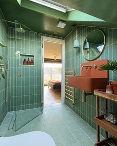 a green tiled bathroom with a sink and shower