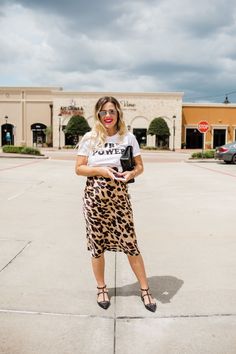 Leopard print is trending this summer and Uptown With Elly Brown shares how to style this trend. This leopard print midi skirt pairs perfectly with a graphic tee and heels. Follow for more elevated outfit ideas, summer fashion trends, and style guides. Leopard Slip Dress, Houston Fashion, Summer Pregnancy, Printed Midi Skirt, Mom Outfits, Casual Street Style, Outfit Posts