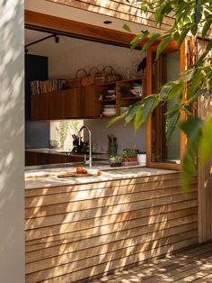 an outdoor kitchen with wooden walls and flooring is shown in the sunlight from outside