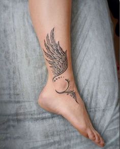 a woman's foot with a tattoo on it and an angel wing above the toe