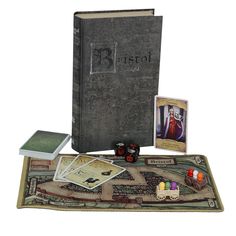 an open book with cards, dices and other items sitting on top of it