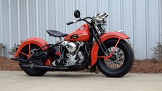 an orange motorcycle parked in front of a building