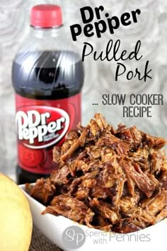 pulled pork slow cooker recipe in a white bowl next to an apple and bottle of dr pepper pulled pork