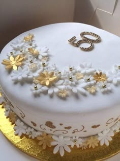 a white cake decorated with flowers and the number twenty five on it's side