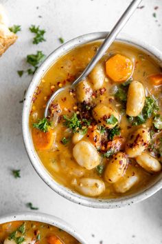 two bowls filled with soup and some bread