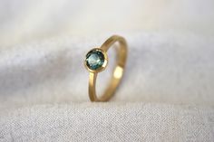 Dainty yellow gold ring with a bi-colour green/blue round sapphire on a fine tapered band with a brushed wire wool finish. Parti Sapphire, Diamond Cluster Ring, Matte Gold